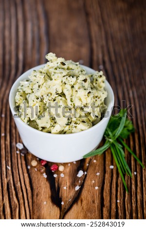 Herb Butter in a small bowl (on wooden background)