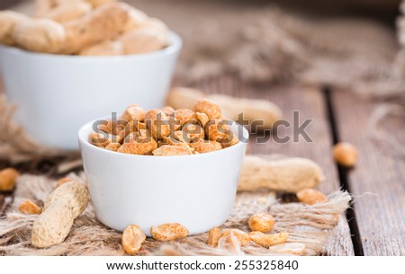 Heap of Peanuts (roasted and salted) on dark wooden background