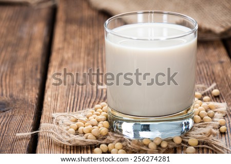 Soy Milk with some Seeds (close-up shot) on wooden background