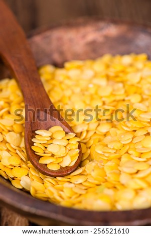 Portion of Yellow Lentils on vintage wooden background