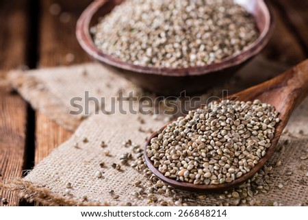 Portion of Hemp Seeds (close-up shot) on an old wooden table