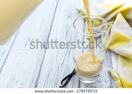 Portion of homemade Vanilla Milk (on rustic wooden background)