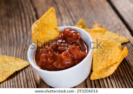 Nachos with Salsa Sauce (close-up shot) on wooden background
