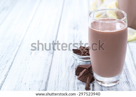 Cold Chocolate Milk drink (close-up shot) on wooden background