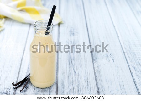 Fresh made Vanilla Milk (close-up shot) on wooden background
