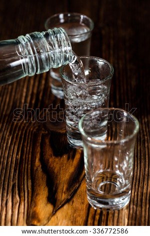 Vodka Shot with ice on an old rustic wooden table
