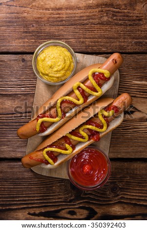 Homemade Hot Dog with ketchup and mustard on rustic wooden background