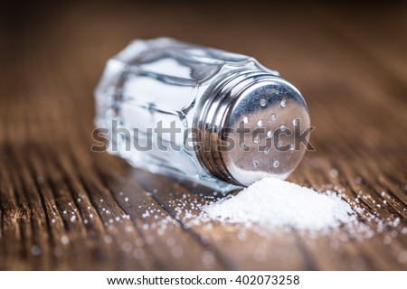 Old wooden table with a Salt Shaker (close-up shot; selective focus)