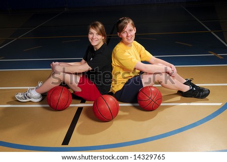 Two teenage basketball players in school gymnasium