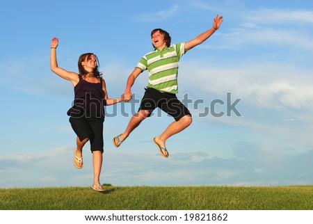 A young couple jump for joy.