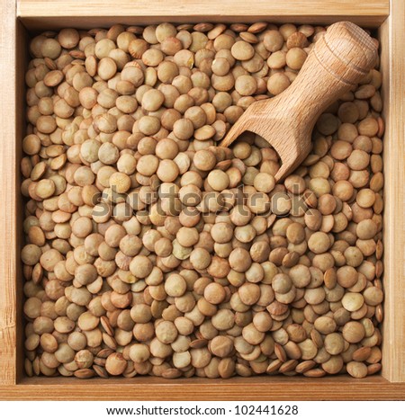 wooden box full of laird lentils with scoop