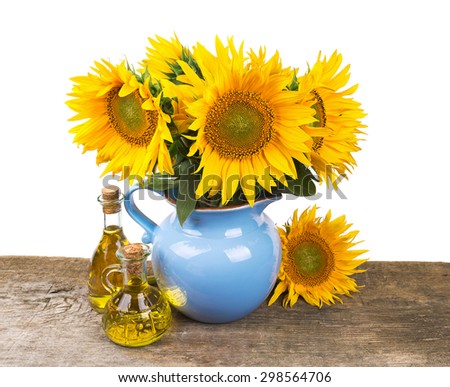 composition with sunflowers and sunflower oil on wooden desk over white background