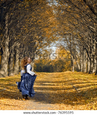 girl dressed in a retro-style run on the autumn alley. She looked back. She in a really good mood