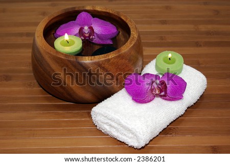 Floating green candles and orchids in a bowl of water