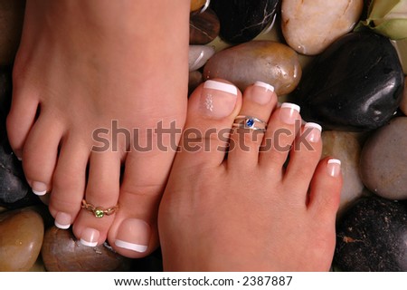 Two pedicured feet on healing pebbles