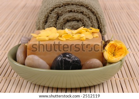 Olive oil soap, pebbles, petals and towel