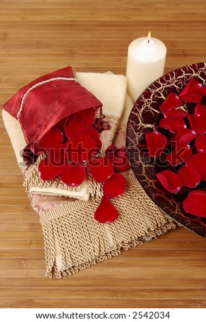 Sachet of rose petals, luxurious towels, candle and Italian glass dish filled with red rose petals