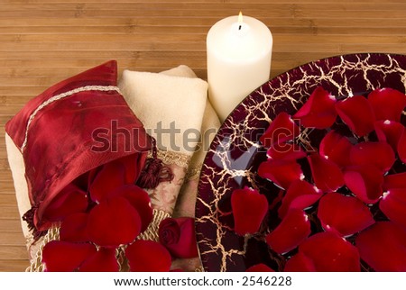 Sachet of rose petals, luxurious towels, candle, Italian dish filled with red rose petals