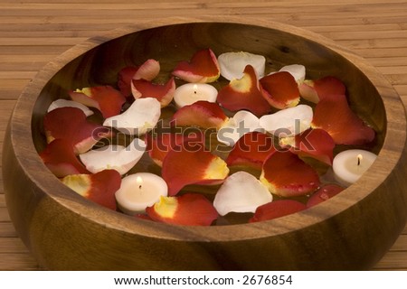 Floating candles, rust colored and white rose petals in water