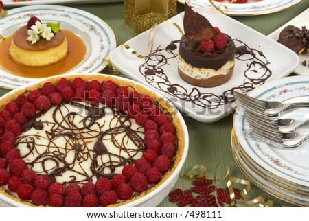 Elegant table with many desserts and fruits (éclair, pecan swirl cake, raspberry pie, rice pudding, cheese cake, creme caramel, and more)