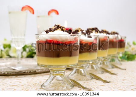 Trifle with chocolate pudding, vanilla pudding, strawberries, chocolate cake pieces, whip cream, walnuts and chocolate curls and champagne