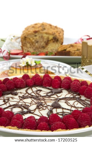 Elegant table with many desserts and fruits ( pecan swirl cake, raspberry pie, creme caramel, and more)