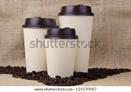 Three disposable coffee cups with plastic lid.