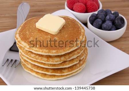 Stack of pancakes with fruits on background. Top view.