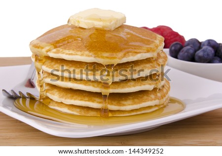Stack of pancakes with fruits on background. Front view.