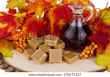Presentation of maple syrup and sugar cream fudge on wooden plate.