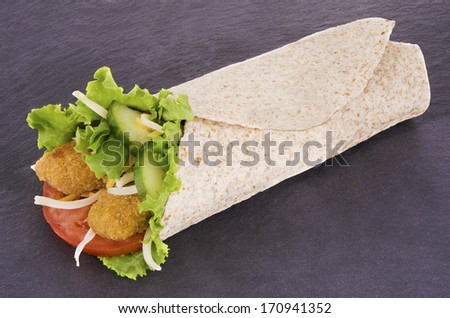 Chicken wrap. Cheese, lettuce and tomato,  on slate plate background.