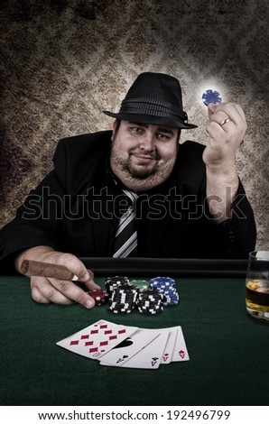 Poker player holding cigar, close up. Playing cards on table.