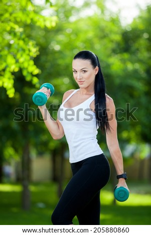 Portrait of cheerful woman in fitness wear exercising with