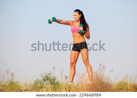 Portrait  woman in fitness wear exercising with dumbbell,