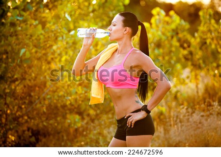Athlete refreshing with bottle of water after running workout outdoors. marathon runner drinking, healthy active lifestyle