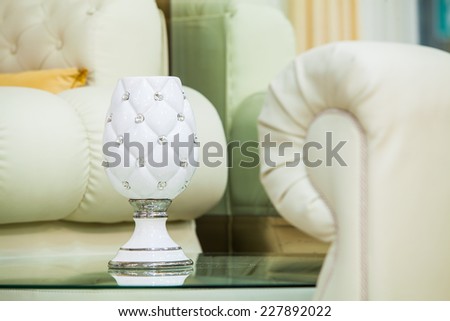 White sofa and glass end table with vase. Horizontal shot.