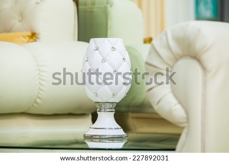 White sofa and glass end table with vase. Horizontal shot.