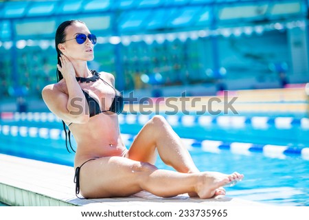 Young pretty fashion sport woman posing  in summer  in hot weather in bikini on pool party