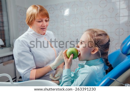 Dentist gives the child a green apple