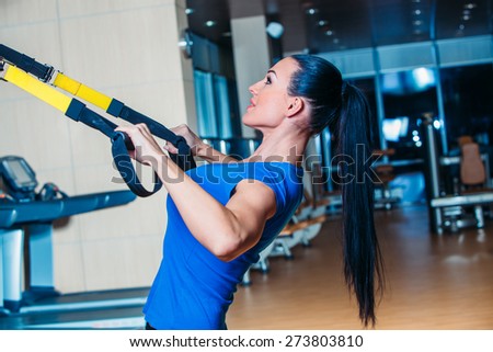 fitness, sports, exercise, technology and people concepts - smiling young woman doing exercise at the gym