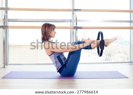 fitness, sport, training and lifestyle concept -  girl doing pilates with ring