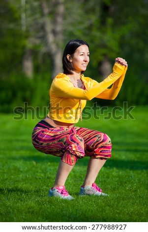Push ups or press ups exercise by young woman. Girl working out on grass crossfit strength training in the glow of the morning sun against a white sky with copyspace. Mixed race Asian Caucasian model.