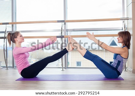 Aerobics Pilates personal trainer helping women group in a gym class