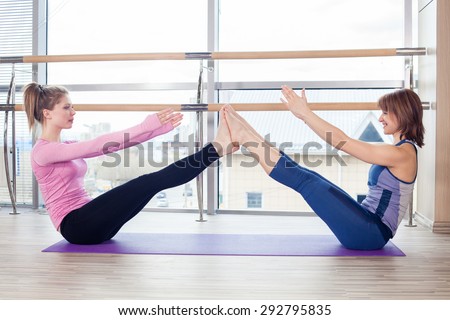 Aerobics Pilates personal trainer helping women group in a gym class