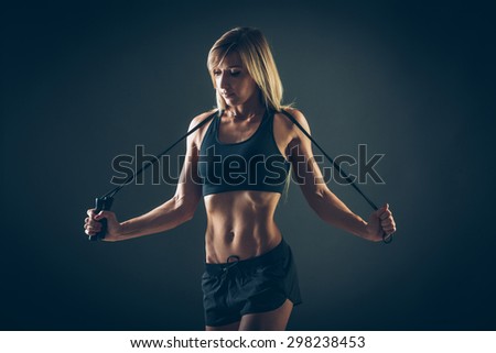 Sport, activity. Cute woman with skipping rope. Muscular woman  black background.