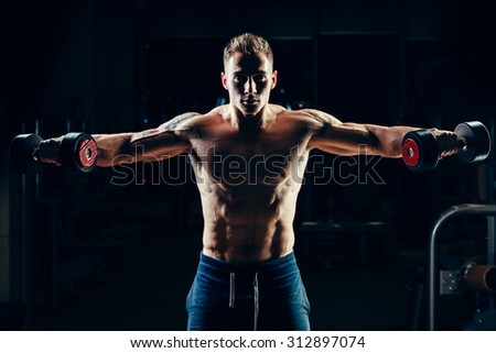 Athlete muscular bodybuilder training back with dumbbell  in the gym.