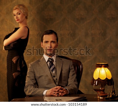 Man in suit  with woman behind him.