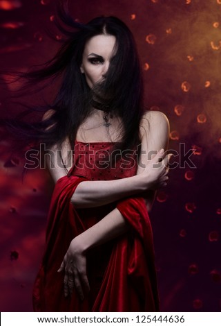 Beautiful vampire woman in red dress