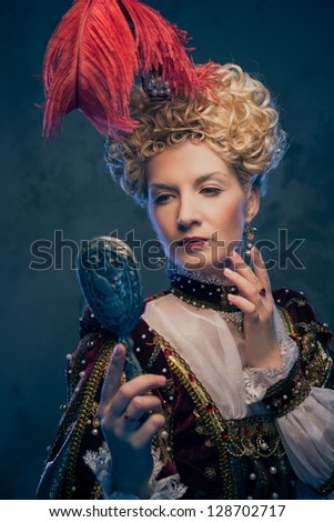 Haughty queen in royal dress with mirror Haughty queen in royal dress with mirror