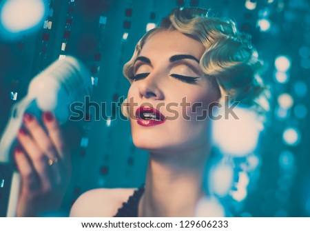 Elegant blond retro woman singer with beautiful hairdo and red lipstick